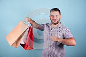 Young boy  young boy doing shopping with paper bags blue background