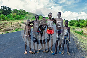 Young Boys of Benna Tribe with Traditional Body Painting on the Long Wooden Sticks posing for the picture