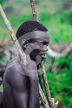 Young Boys of Benna Tribe with Traditional Body Painting on the Long Wooden Sticks posing for the picture