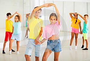 Young boys and girls dancing salsa in dance room