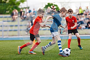 Young boys playing a football game. Training and soccer match between youth school teams