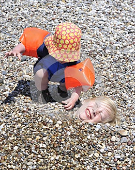 Young boys playing with pebbles at beach