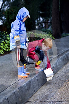 Young boys playing with toy boat in the rain 2