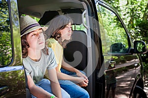Young boys are sitting in a van looking out