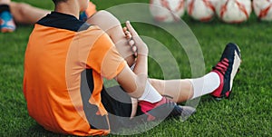 Young Boys in Sports Uniform Sitting and Stretching on Grass Field. Kids in Soccer Club on Training Unit
