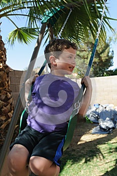 Young boys swings on a swingset. photo