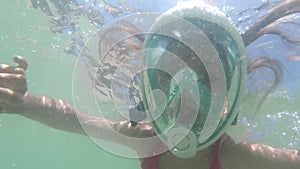 Young brave girl kid snorkeling and swimming with mask underwater view in sea