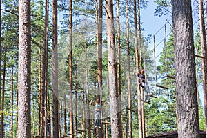 Young brave woman climbing in a adventure rope park