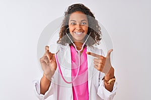 Young brazilian doctor woman using stethoscope standing over isolated white background very happy pointing with hand and finger