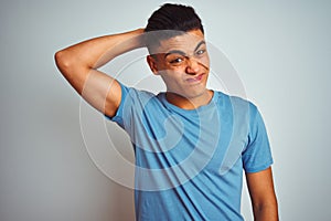 Young brazilian man wearing blue t-shirt standing over isolated white background confuse and wonder about question