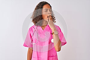 Young brazilian nurse woman wearing stethoscope standing over isolated white background bored yawning tired covering mouth with