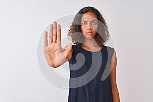 Young brazilian woman wearing blue dress standing over isolated white background doing stop sing with palm of the hand