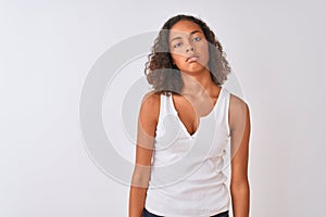 Young brazilian woman wearing casual t-shirt standing over isolated white background looking sleepy and tired, exhausted for