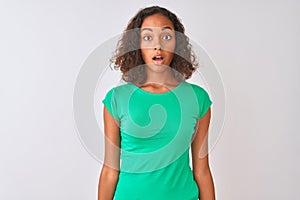 Young brazilian woman wearing green t-shirt standing over isolated white background afraid and shocked with surprise expression,