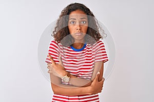 Young brazilian woman wearing red striped t-shirt standing over isolated white background shaking and freezing for winter cold