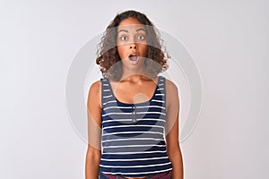 Young brazilian woman wearing striped t-shirt standing over isolated white background afraid and shocked with surprise expression,