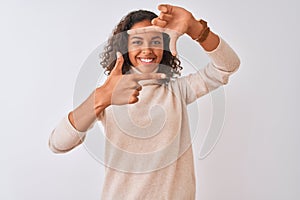 Young brazilian woman wearing turtleneck sweater standing over isolated white background smiling making frame with hands and