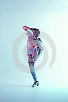 Young breakdancer guy in cap and sunglasses dancing hip-hop in neon light. Dance school poster