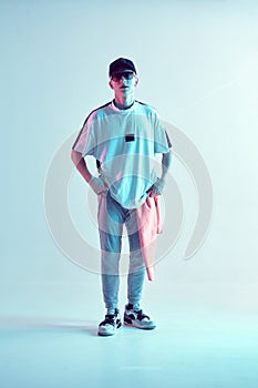 Young breakdancer guy in cap and sunglasses stands in neon light. Dance school poster. Battle competition announcement