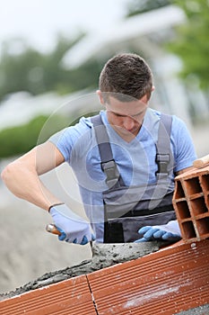 Young brick layer apprentice at work