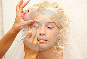 Young bride doing make up