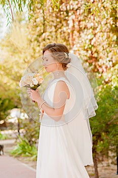 Young bride in a garden in a white dress