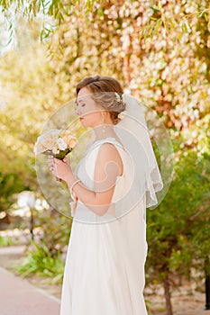 Young bride in a garden in a white dress