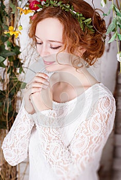 Young bride in a green wreath praying for happyness