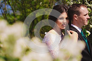 Young bride and groom in a lush garden in the spring