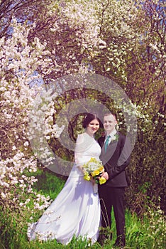 Young bride and groom in a lush garden in the spring