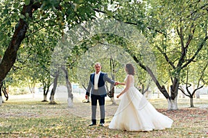 Young bride and groom walking in a summer Park with green trees