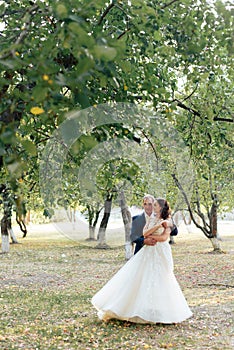 Young bride and groom walking in a summer Park with green trees