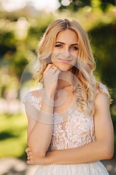 Young bride stand in the park fron of green background