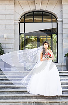 Young bride in wedding dress holding bouquet