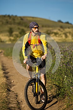 Young bright man on mountain bike