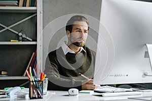 Young man working with computer at desk in office
