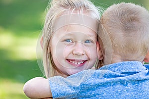 Young Brother and Sister Hugging Outdoors