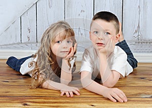 Young brother and sister laying together in floor
