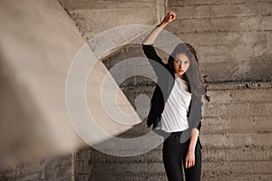 Young brunet woman standing outside in black jacket, jeans wearing hills . horizontal