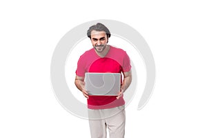 young brunette advertiser man holding laptop on white background