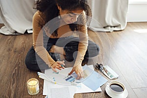 Young brunette african american woman creating her Feng Shui wish map using scissors