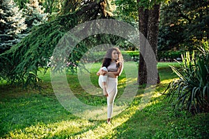 Young brunette asian woman practicing yoga during workout in park