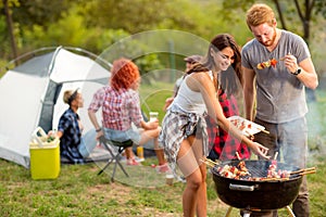 Young brunette with boyfriend serving on plate barbecue