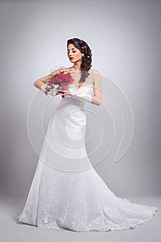 A young brunette bride holding flowers