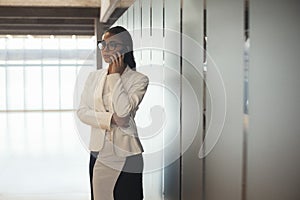 Young brunette business spectacled woman talking by mobile phone.