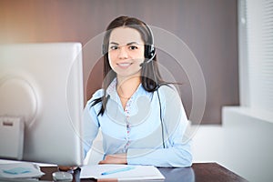Young brunette business woman looks like a student girl working in office. Hispanic or latin american girl talking by