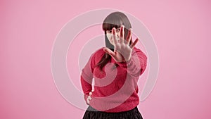 Young brunette caucasian woman over pink isolated background doing stop sing with palm of the hand.