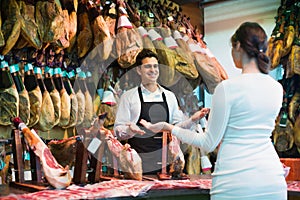 Young brunette choosing iberico and serrano jamon