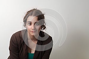 young brunette curly hair woman smiling and wearing brown jacket business suit on white background