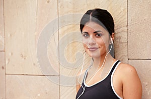 Young brunette with earphones and secretive smile